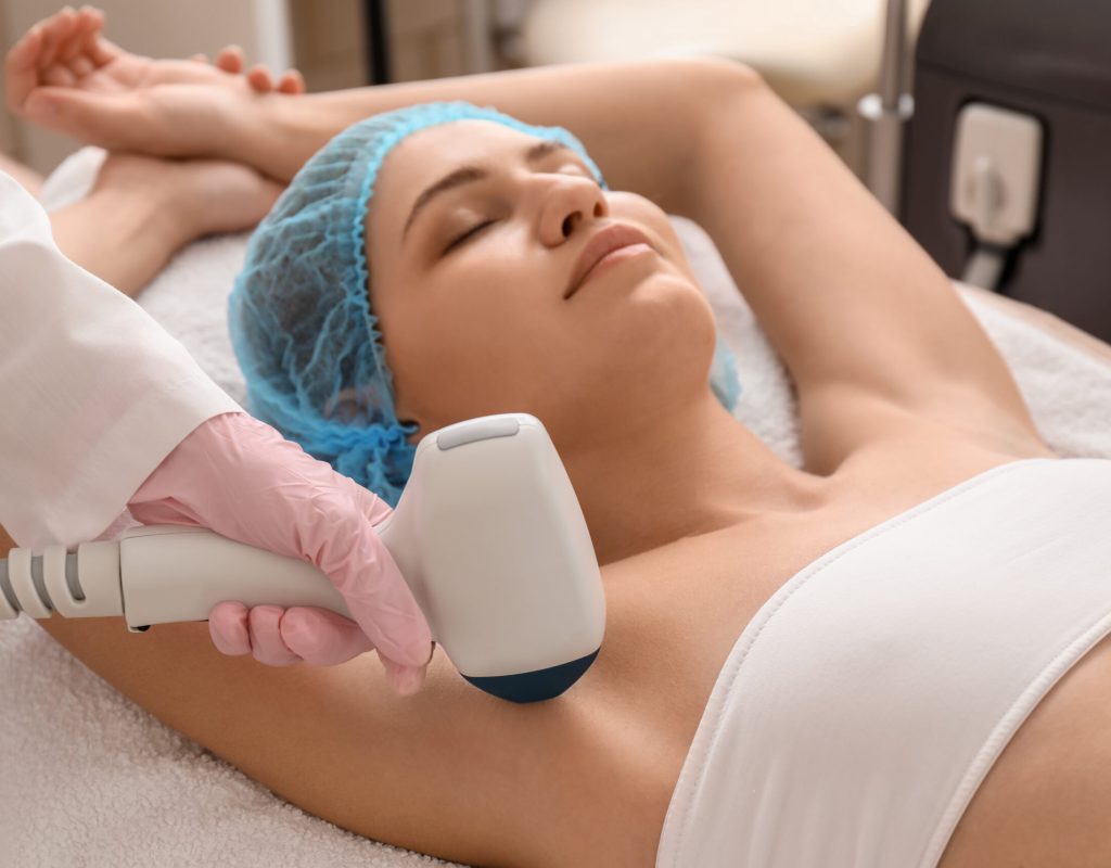 Beautiful woman undergoing procedure of laser hair removing in beauty salon Beautiful woman undergoing procedure of laser hair removing in beauty salon