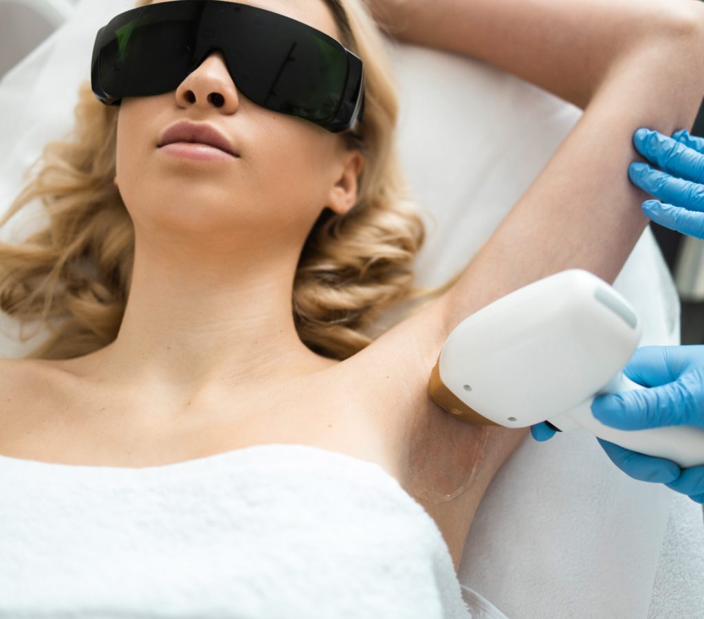 Underarm laser epilation. Beautician removing hair of young woman’s armpit. Smooth skin concept Underarm laser epilation. Beautician removing hair of young woman's armpit. Smooth skin concept